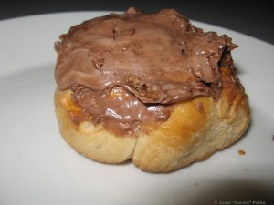 Itse leivottu lämmin pulla, jonka päällä suklaalevitettä